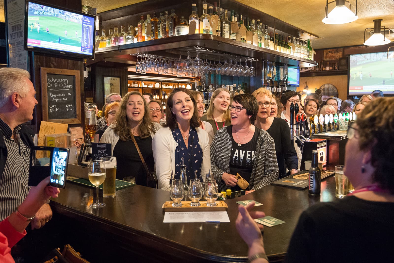 Cantanti del coro che si esibiscono in un pub locale